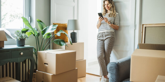 A woman surrounded by boxes, standing in her new home