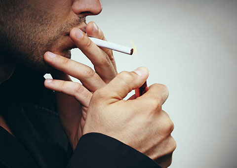 A man, about to light a cigarette