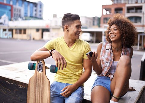 Young people, laughing with one another while sitting down